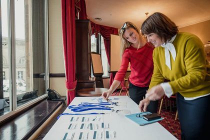 women collect passes from conference table