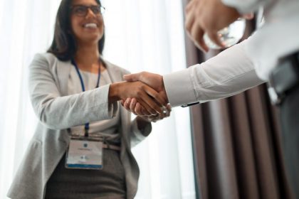 woman shakes hands with obscure man