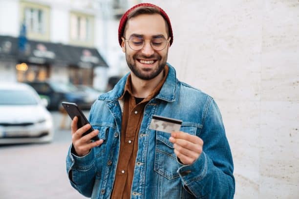 man smiles at bank card