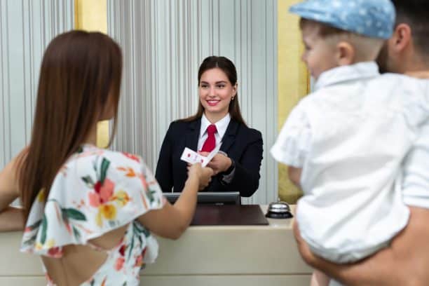 hotel receptionist gives family a room key